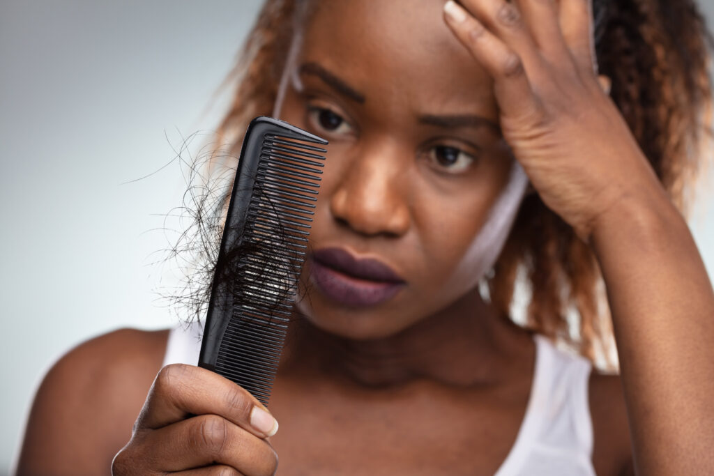 iStock 863685450 A woman looking at hair in her comb